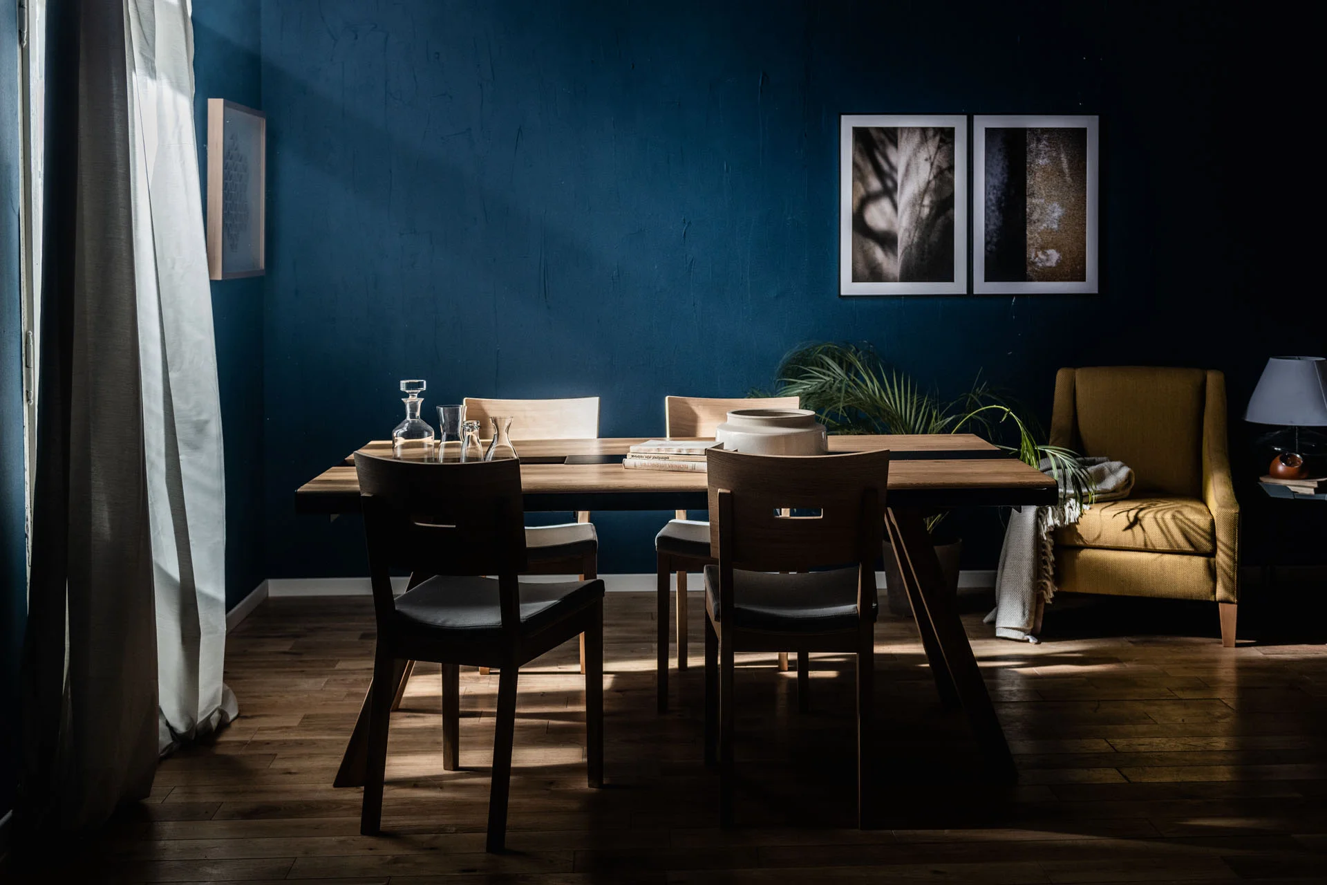Elegancka jadalnia z ciemnoniebieską ścianą